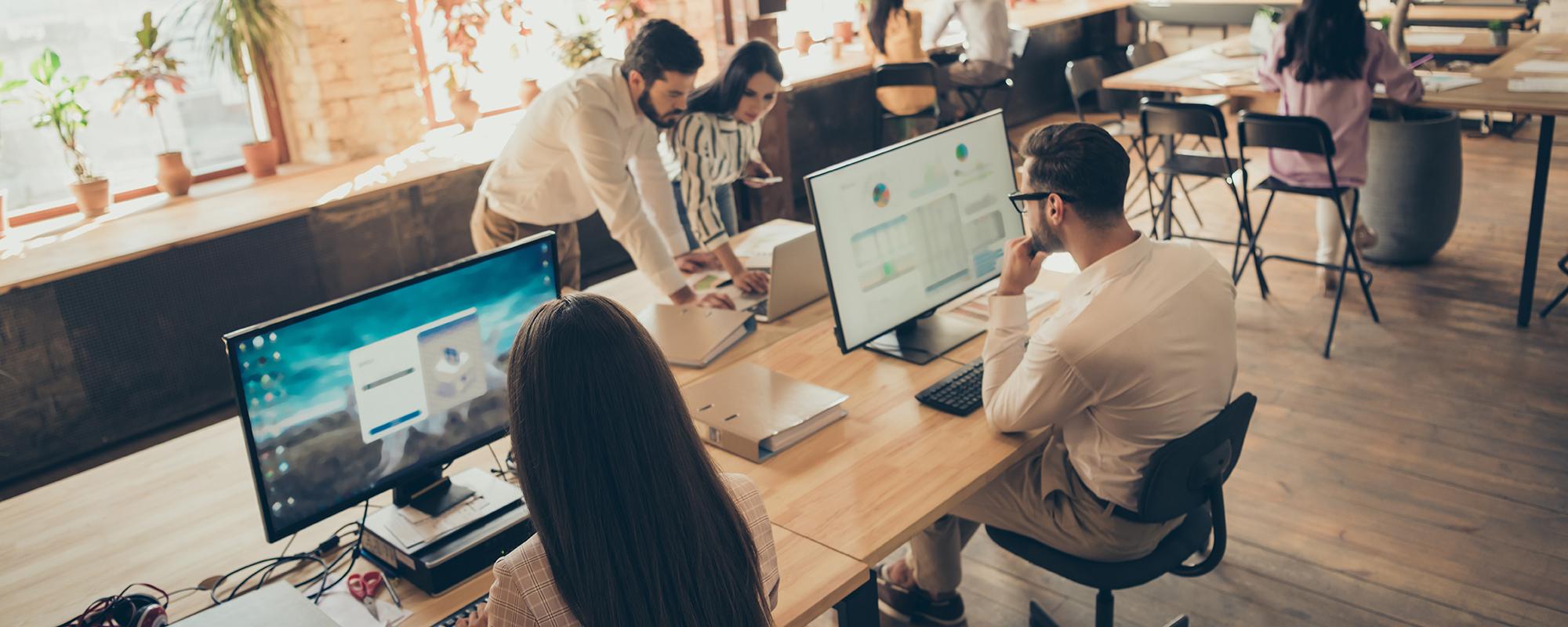 Arbeiten im Coworking-Space. Großraumbüor mit vielen Menschen, die gemeinsam und allein arbeiten.