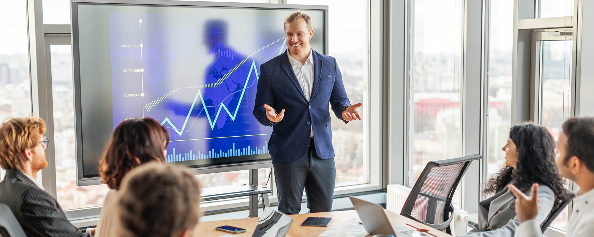 Sales-Meeting. Verkaufsleiter präsentiert Kurven und Gewinne einer interessierten Gruppe an Vertrieblern.