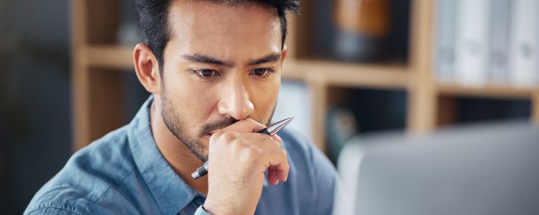 Ein konzentrierter Mitarbeiter prüft am Computer sensible Daten und symbolisiert so die Wichtigkeit von Datenschutz am Arbeitsplatz und dem Schutz von Mitarbeiterdaten gemäß DSGVO.