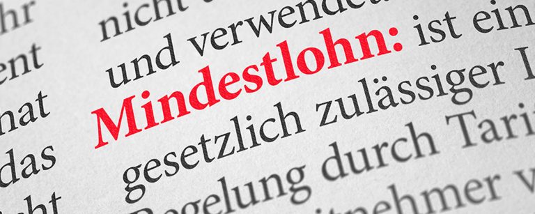 Aufnahme eines Wörterbuchs, in dem das Wort Mindestlohn in rot hervorgehoben wird.